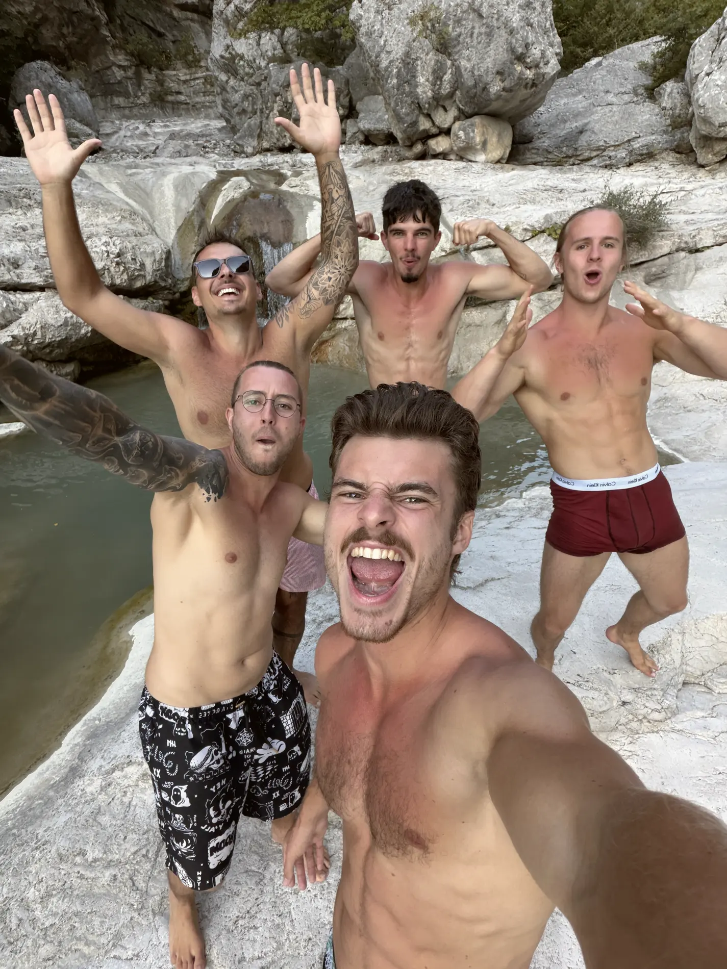 Fünf Freunde jubelnd am Wasserfall